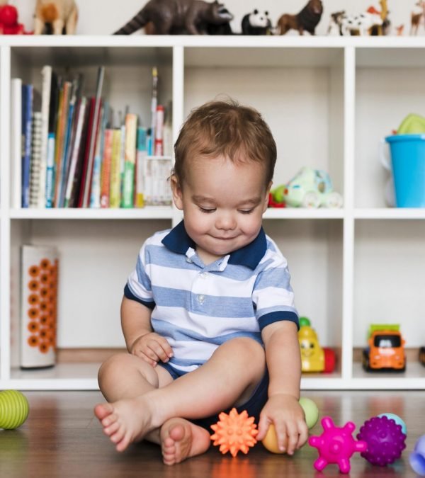 front-view-of-happy-cute-baby-boy-playing-with-toys
