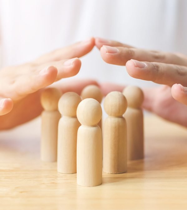 Protection people health and insurance concept. Hand shield protect wooden human on table